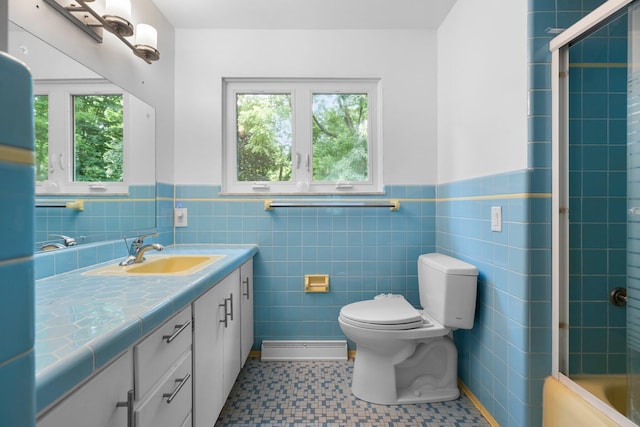 bathroom with toilet, wainscoting, tile walls, and vanity