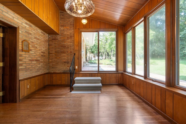 unfurnished sunroom with lofted ceiling, a chandelier, and wood ceiling