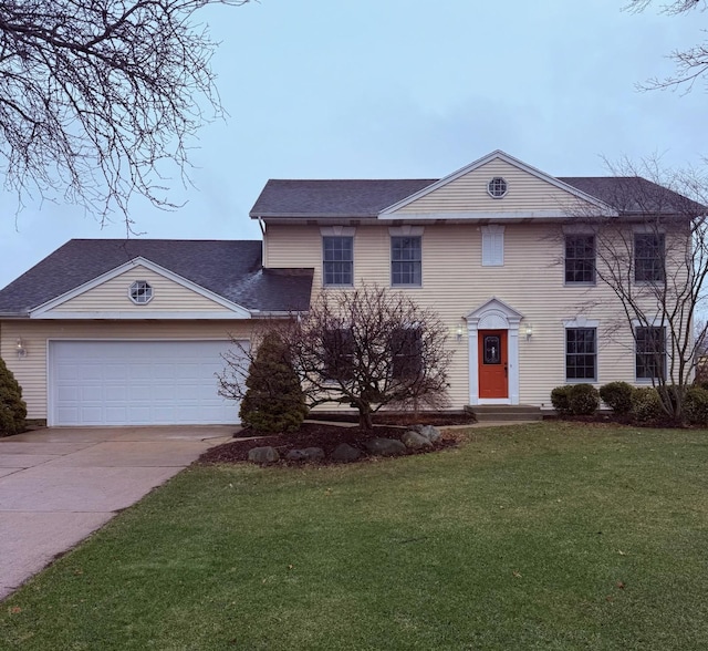 view of front facade featuring an attached garage, driveway, and a front yard