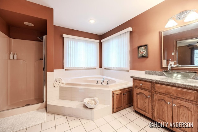 bathroom with a garden tub, tile patterned flooring, a stall shower, and vanity