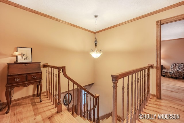 stairs featuring ornamental molding, wood finished floors, and baseboards