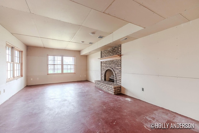 unfurnished living room with concrete flooring, visible vents, and a fireplace