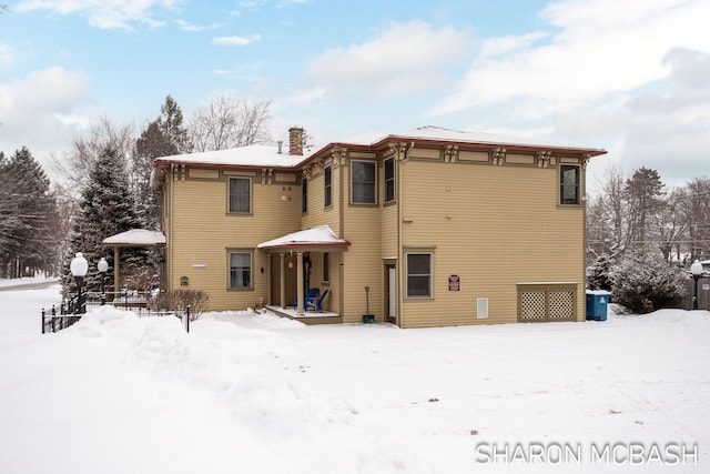 snow covered house with a chimney