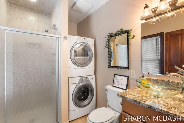 washroom featuring a sink, laundry area, and stacked washer / dryer