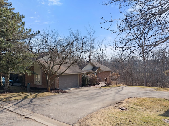 view of front of property with aphalt driveway, brick siding, and an attached garage