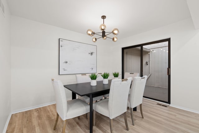 dining room with light wood-type flooring, baseboards, and an inviting chandelier