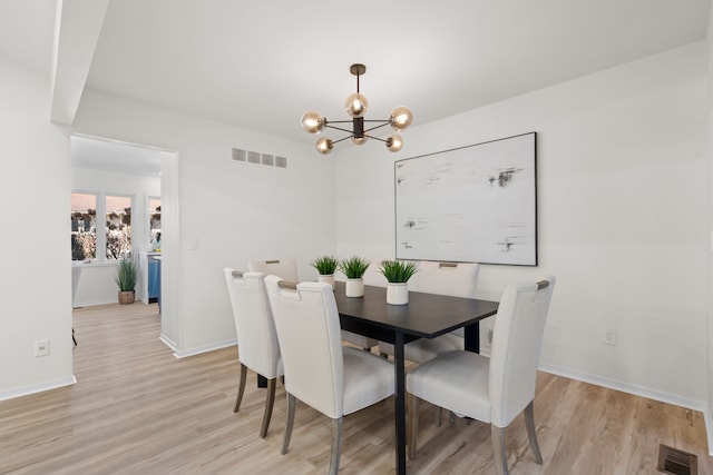 dining room featuring visible vents, a chandelier, and light wood-style flooring