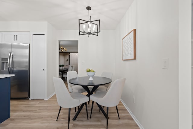 dining room featuring a chandelier, baseboards, and light wood-style floors