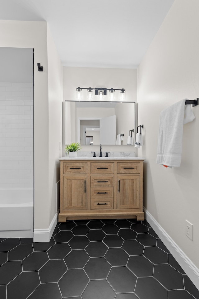 bathroom with vanity, baseboards, and tile patterned flooring