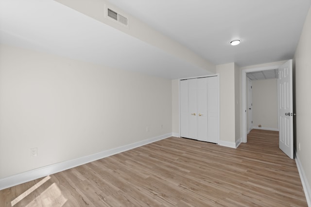 unfurnished bedroom featuring baseboards, visible vents, a closet, and light wood-type flooring