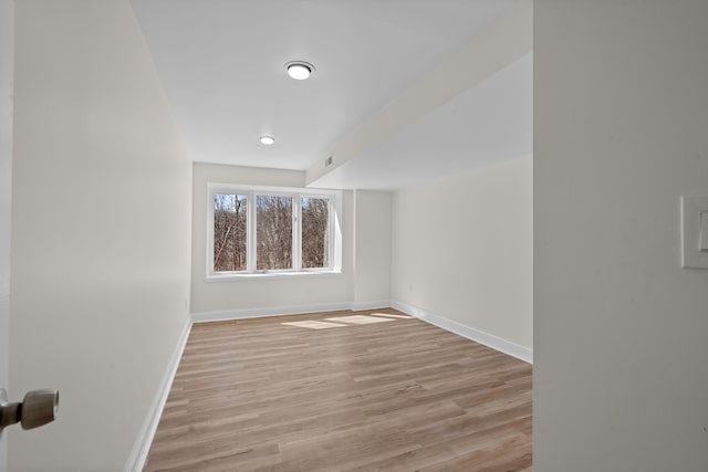 empty room with baseboards and light wood-style floors