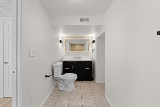 bathroom featuring baseboards, toilet, vanity, and tile patterned flooring