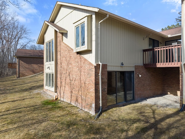 rear view of property with brick siding and a lawn