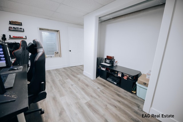 office space featuring wood finished floors, a paneled ceiling, and baseboards