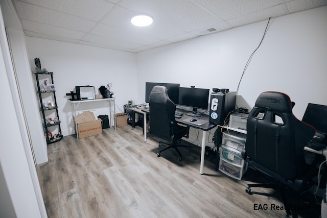 home office with a drop ceiling, wood finished floors, and visible vents