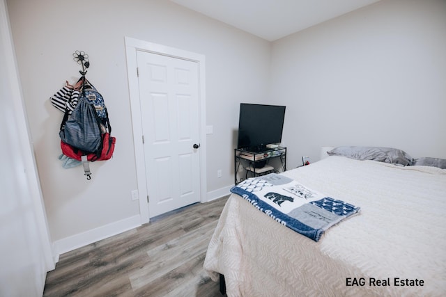 bedroom with baseboards and wood finished floors