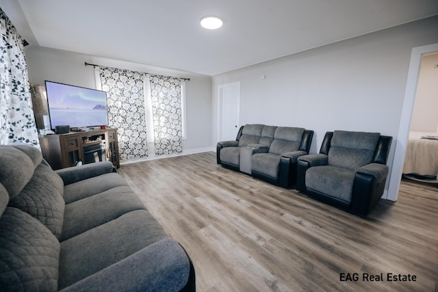 living area with baseboards and wood finished floors