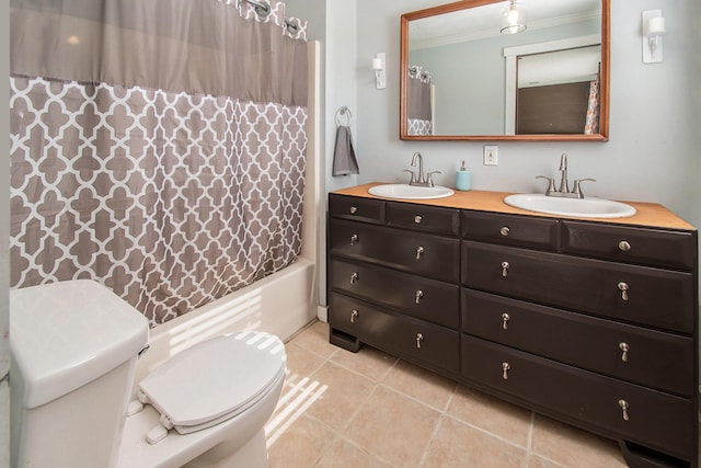 full bathroom featuring toilet, crown molding, a sink, and tile patterned floors