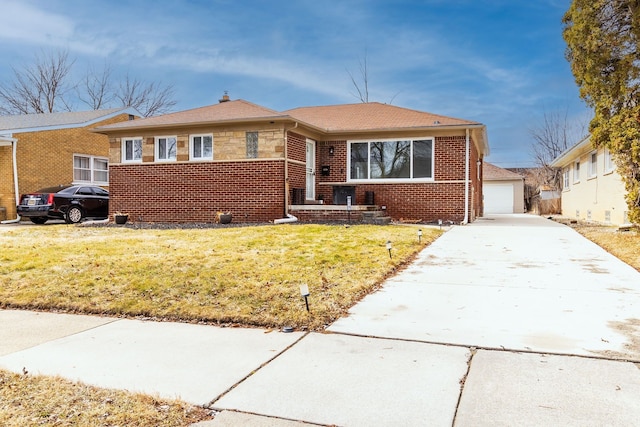 bungalow-style house featuring brick siding, a garage, an outdoor structure, and a front lawn