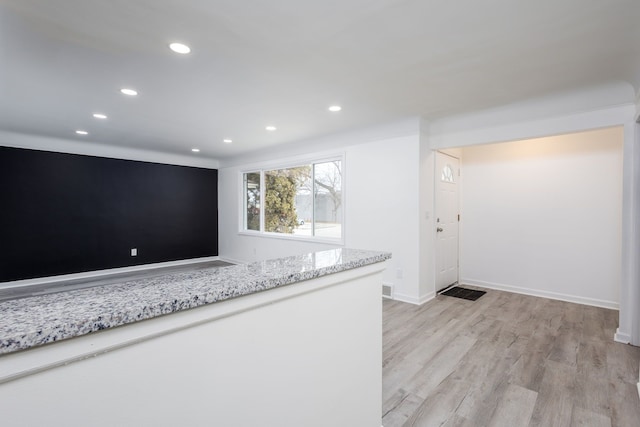 kitchen featuring recessed lighting, light wood-style floors, baseboards, and light stone countertops