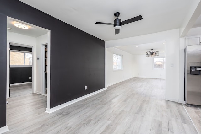 unfurnished living room with baseboards, light wood-style flooring, and a ceiling fan