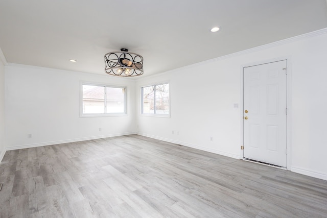 unfurnished room with light wood-type flooring and crown molding