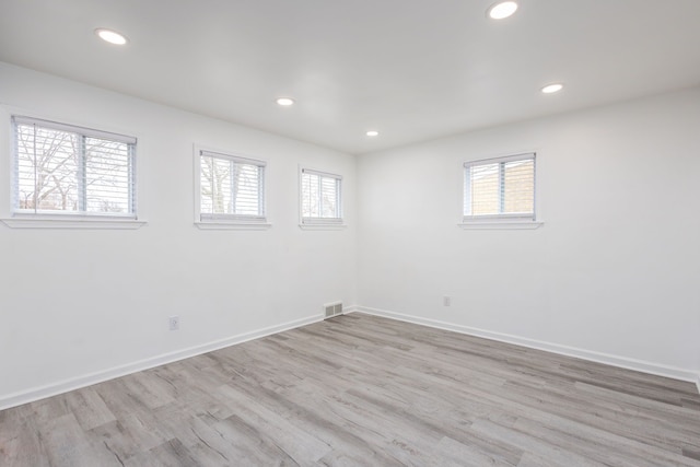 unfurnished room featuring recessed lighting, light wood-style flooring, visible vents, and baseboards