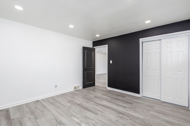 unfurnished bedroom featuring baseboards, visible vents, recessed lighting, a closet, and light wood-type flooring