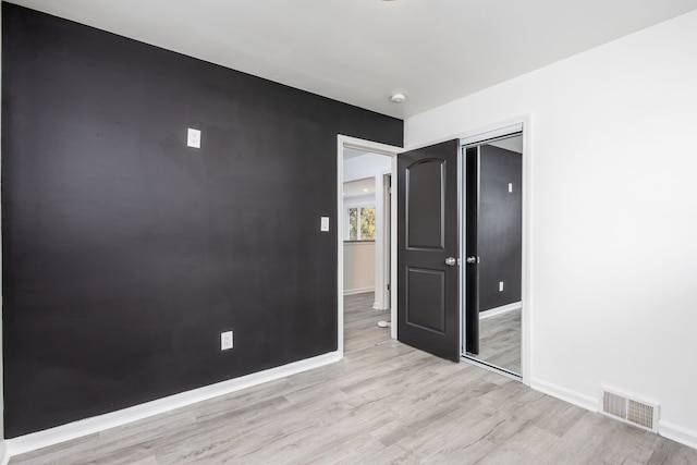 spare room featuring light wood-style flooring, baseboards, and visible vents