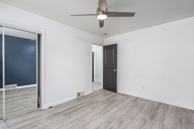 unfurnished room featuring ceiling fan, visible vents, baseboards, and wood finished floors