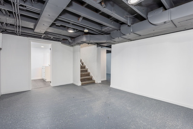 finished basement featuring stairway and baseboards