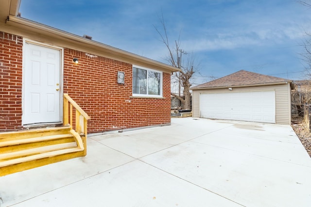 exterior space featuring an outbuilding, a garage, and brick siding