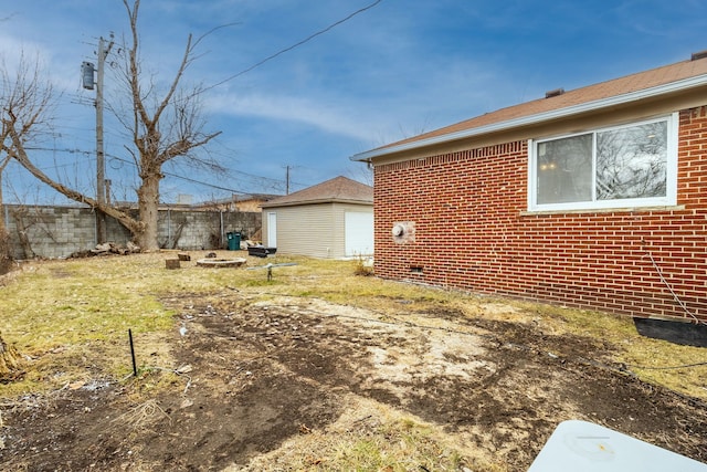 view of yard featuring an outbuilding and fence