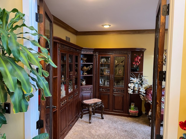 foyer featuring ornamental molding, light carpet, and visible vents