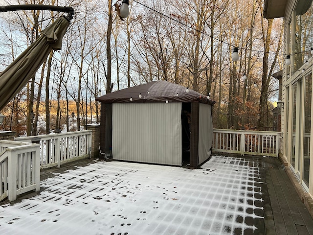 wooden deck featuring an outdoor structure and a storage shed