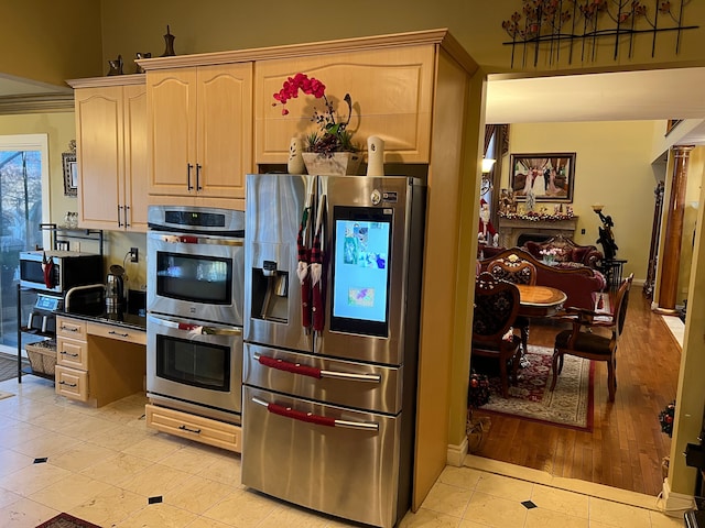 kitchen featuring appliances with stainless steel finishes, light brown cabinets, and light tile patterned floors