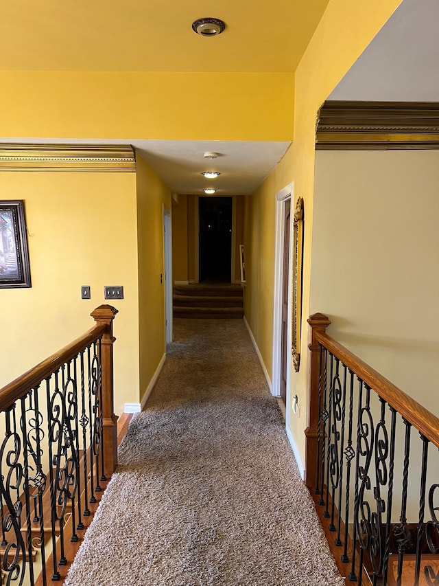 hall featuring carpet, an upstairs landing, and baseboards