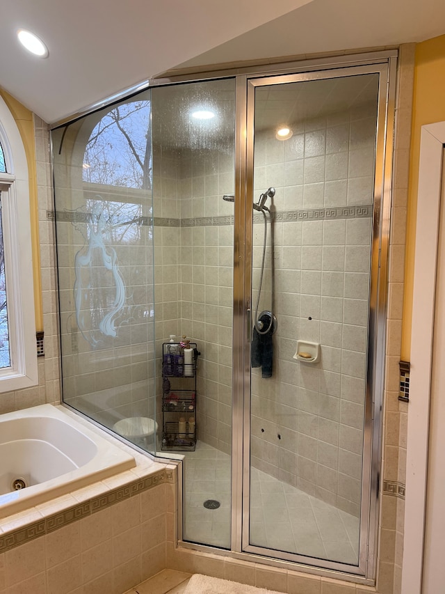 full bathroom featuring a stall shower and a bath