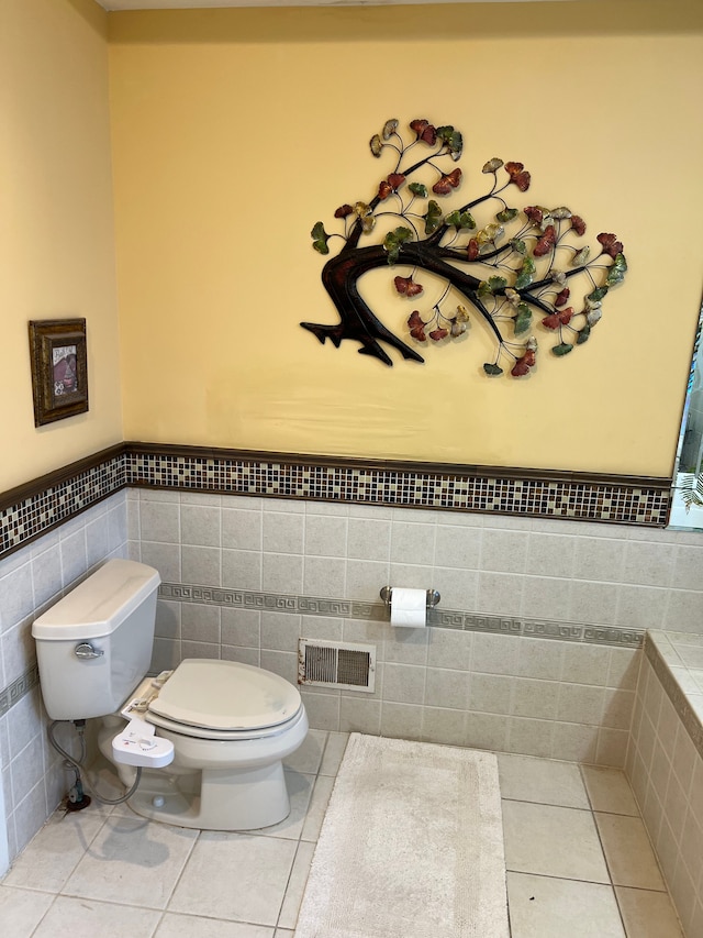 bathroom with toilet, wainscoting, visible vents, and tile patterned floors