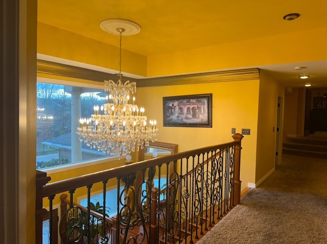 corridor with an upstairs landing, carpet, a notable chandelier, and baseboards