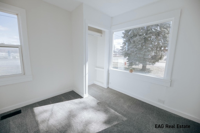 unfurnished bedroom with carpet, visible vents, and multiple windows