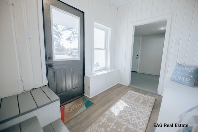 entryway featuring wood walls and light wood-style flooring