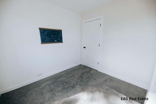 spare room with carpet and baseboards