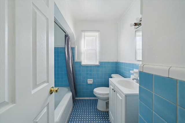 full bathroom with toilet, tile walls, plenty of natural light, and vanity