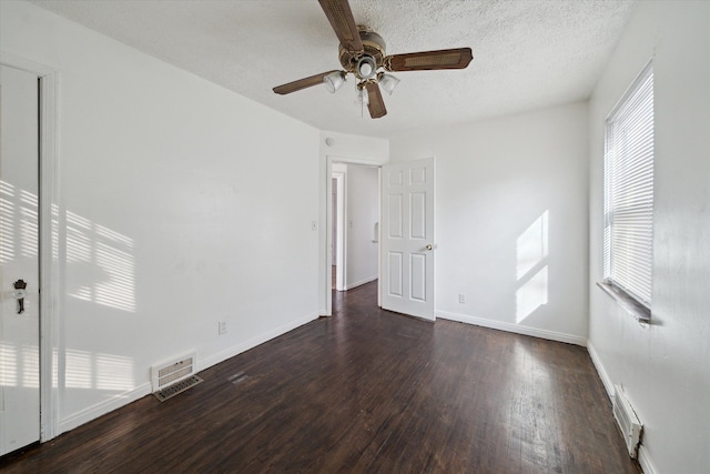 empty room with visible vents, a textured ceiling, ceiling fan, and wood finished floors