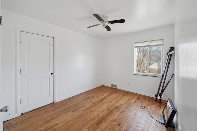 empty room with visible vents, baseboards, light wood-type flooring, and a ceiling fan