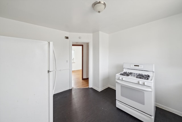 kitchen featuring baseboards, white appliances, and dark wood-type flooring