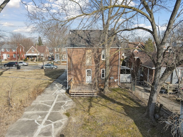 exterior space with a residential view, brick siding, and a shingled roof