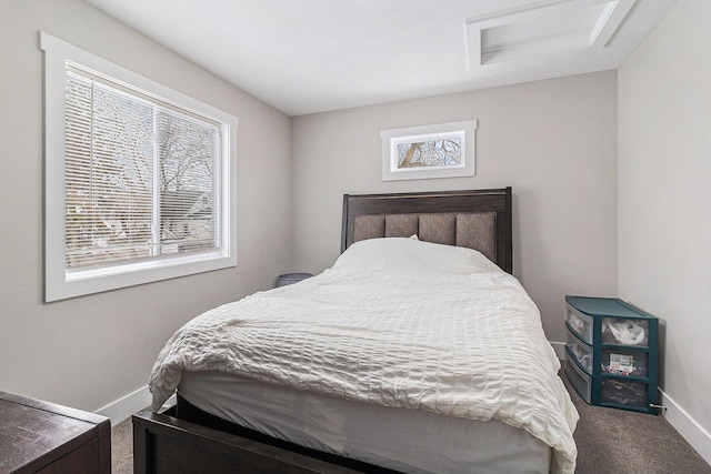 carpeted bedroom featuring attic access and baseboards