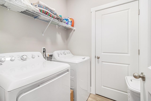 laundry area featuring laundry area, light wood finished floors, and washer and clothes dryer